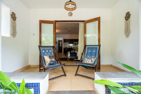 A room with two folding chairs facing a doorway leading to another room.