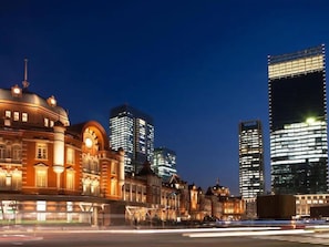 A cityscape at night with historic buildings and modern skyscrapers.