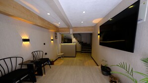 Un interior modern amb zona de menjador, cuina i escala que condueix a un nivell superior.