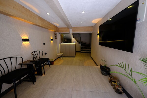 A modern interior with a dining area, a kitchen, and a staircase leading to an upper level.