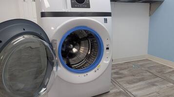 A front-loading washing machine with a blue door, a control panel, and a detergent dispenser.