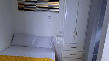 Un dormitorio con cama, armario y una obra de arte en la pared.