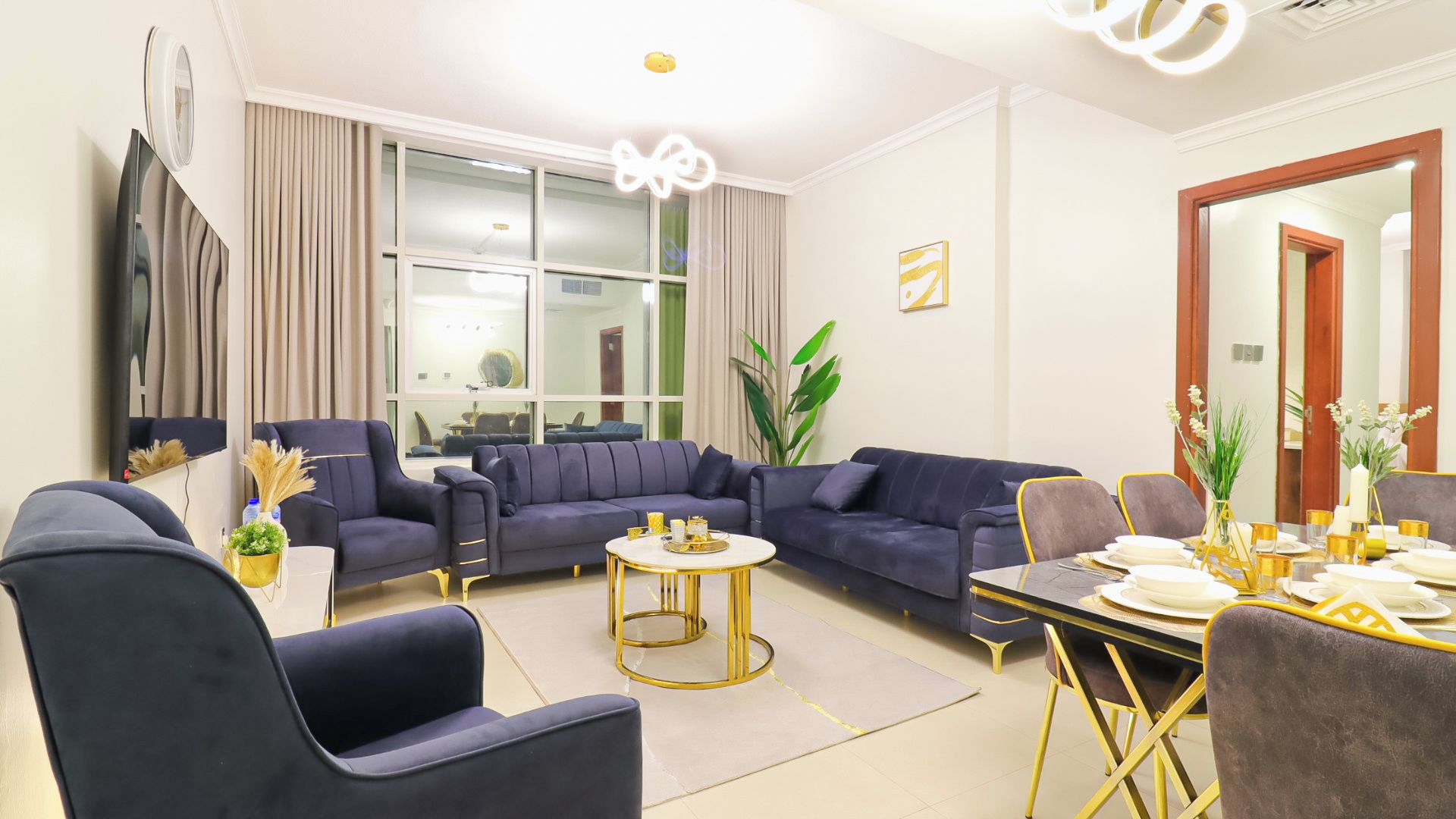 A modern living room with a sectional sofa, a coffee table, and a dining area with a table set for four.