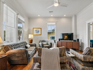 A living room with a sofa, armchairs, a TV, and a fireplace. - Galveston Getaway | Updated Home + Prime Location! (Galveston)