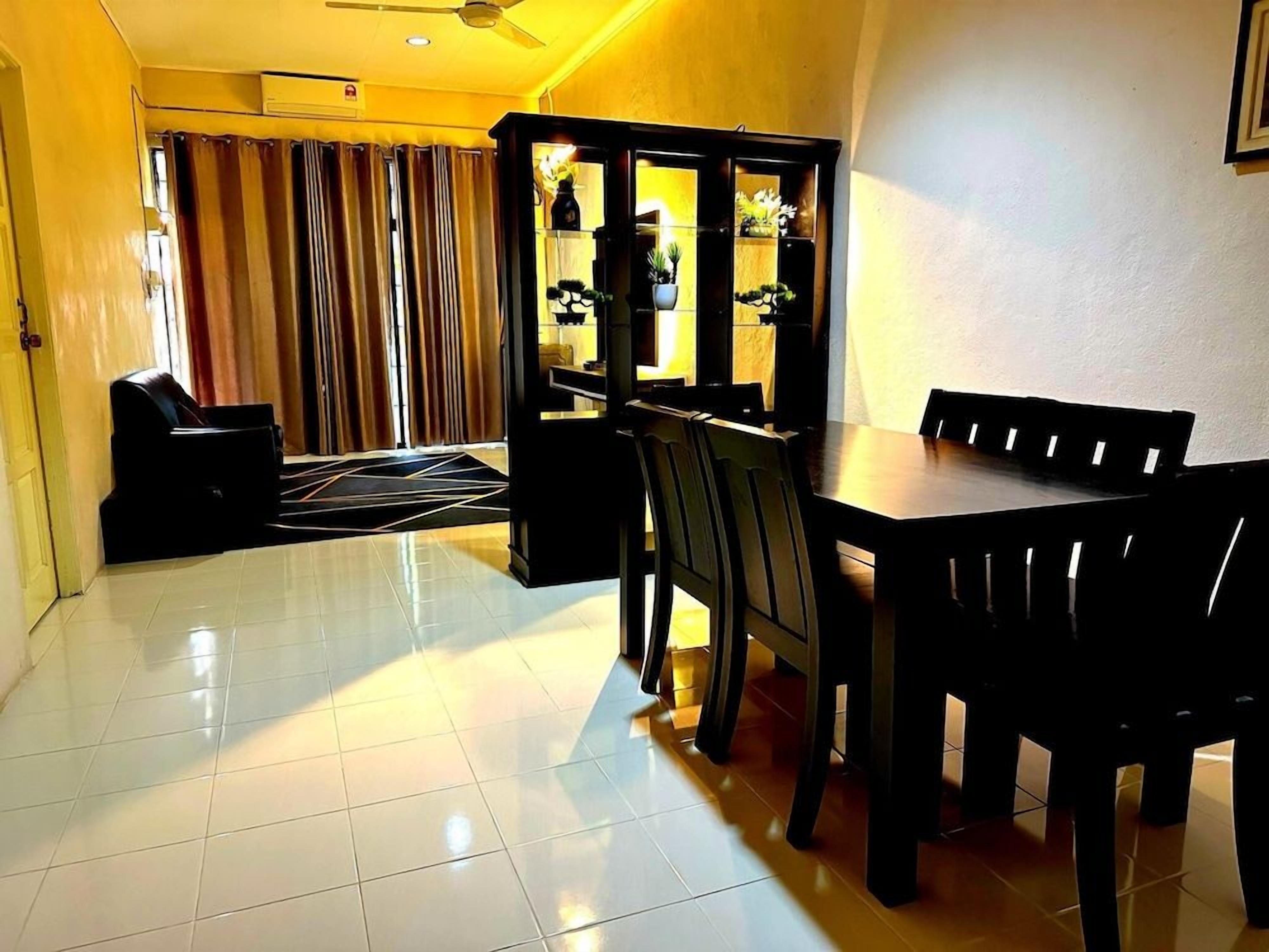A dining area with a table and chairs, a cabinet with glass doors, and a window with curtains.