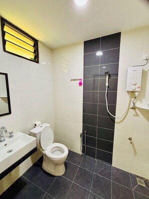 A bathroom with a toilet, sink, and shower area. - Padimas Village Inn (Langkawi)