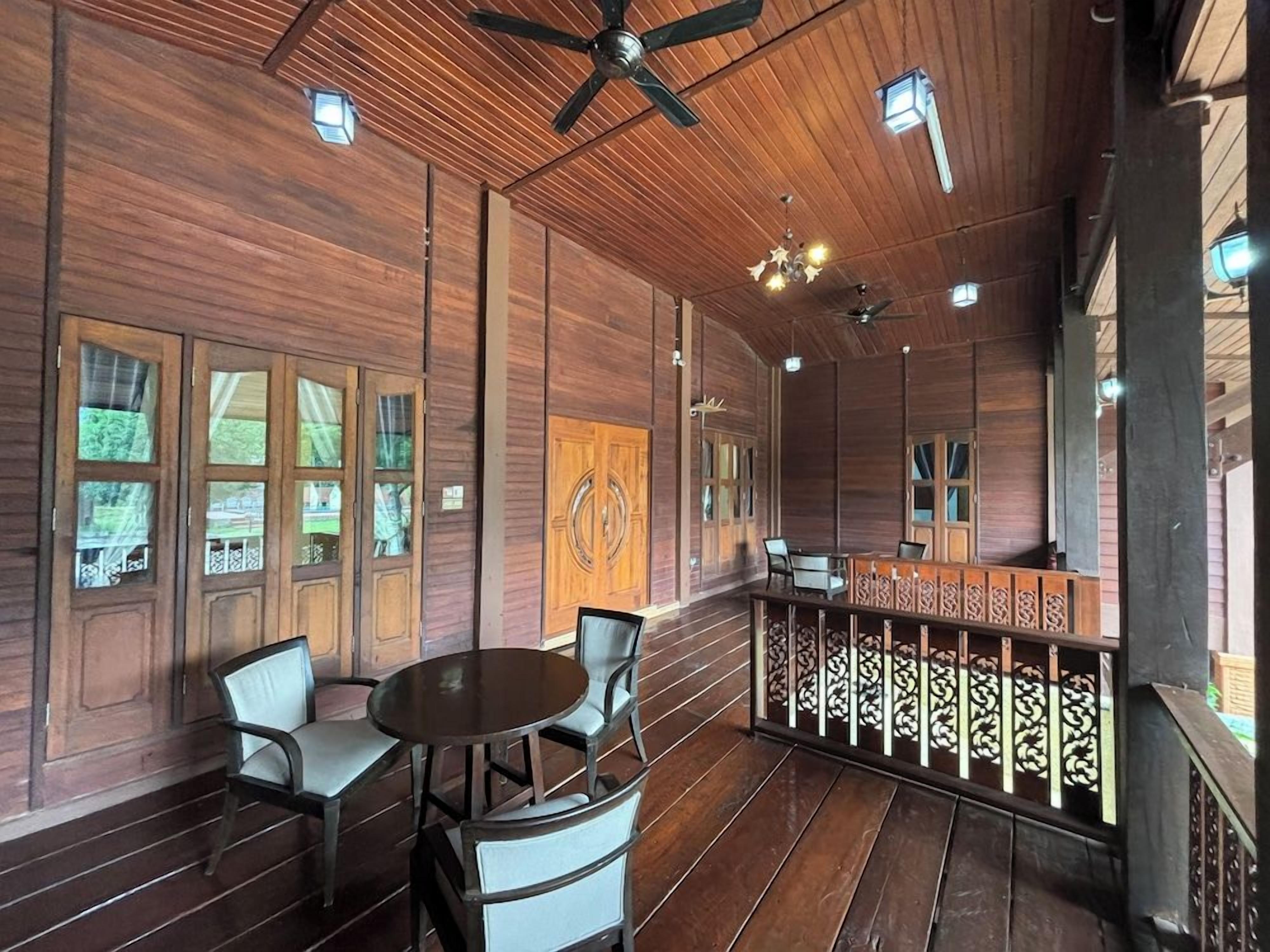 A wooden interior with a bar area, seating, and ceiling fans.