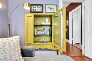 A room with a yellow cabinet, a lamp, and a bookshelf. - Chic 2 Bedroom Flat in Historic District - Wilmington (Wilmington)