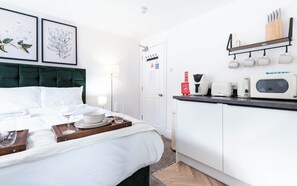 A hotel room with a bed, bedside table, and a kitchenette area. - The Stanley Arms Hotel by Guestz (Seascale)