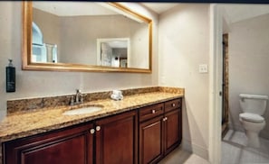 A bathroom with a sink, mirror, and toilet. - Family friendly, Orlando fully equipped 2-bedroom condo over Christmas break. (Orlando)