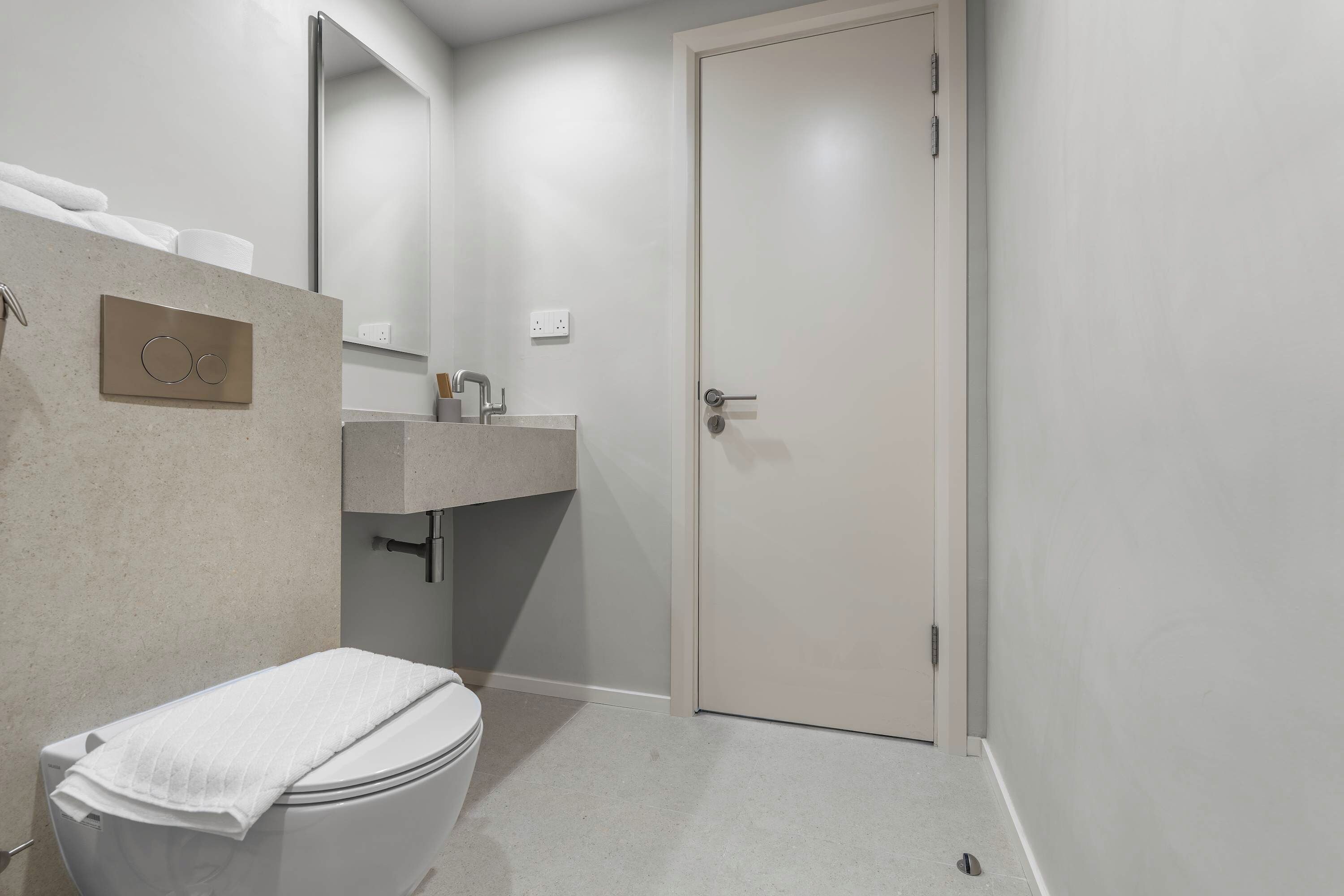 Une salle de bain moderne avec des toilettes, un lavabo et un miroir.