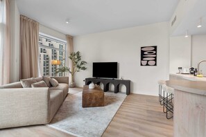 Ein modernes Wohnzimmer mit Sofa, Couchtisch, Fernseher und Bar.
