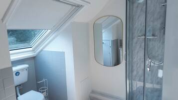 Un baño moderno con ducha, inodoro y lavamanos.