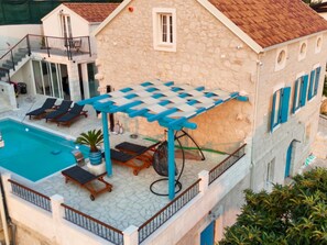 A pool area with lounge chairs and a pergola.