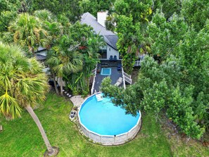 A residential property with a swimming pool surrounded by lush greenery and a deck area. - Nokomis Beach Tropical Tree House! (Nokomis)
