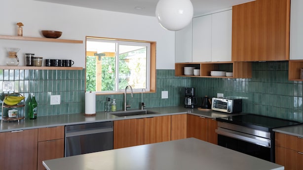 Una cocina moderna con una isla central, electrodomésticos integrados y un ventanal que proporciona luz natural.