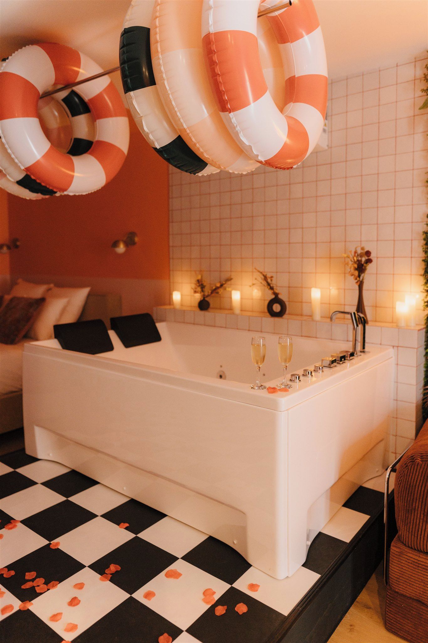 Une salle de bain moderne avec une grande baignoire, un carrelage à motifs et des bouées suspendues au-dessus.