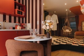 A dining area with a checkered floor, a table set with plates, glasses, and a vase of flowers. - La Pimenta – Escapade romantique & épicée (Dole)