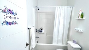 Une salle de bain avec douche, toilettes et lavabo.