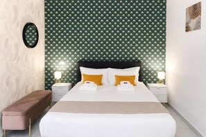 A hotel room with a bed, two bedside tables, a bench, and a patterned wall. - Vatican Design Near Metro Line A (Roma)