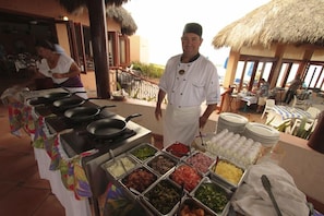 A buffet setup with various food items and a chef. - Torres Mazatlan Condominiums (Mazatlán)