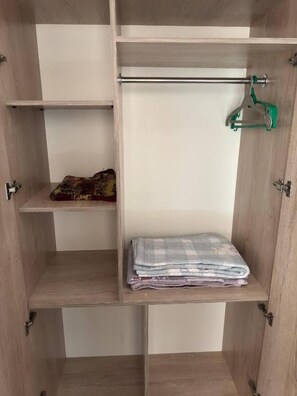 A wooden wardrobe with multiple shelves and a hanging rod. - ANIS-PARI Hotel (Bukhara)