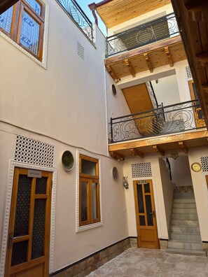 Ein zweistöckiges Gebäude mit Balkon, Treppe und einem Schild, das eine Küche anzeigt.