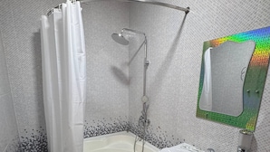 Une salle de bain avec une douche, un lavabo et un miroir.