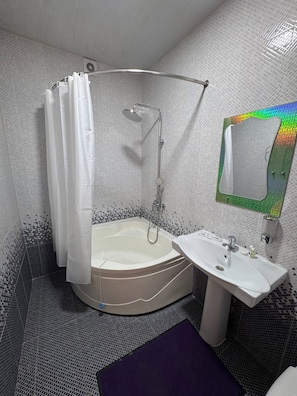 Ein Badezimmer mit Dusche, Waschbecken und Spiegel.