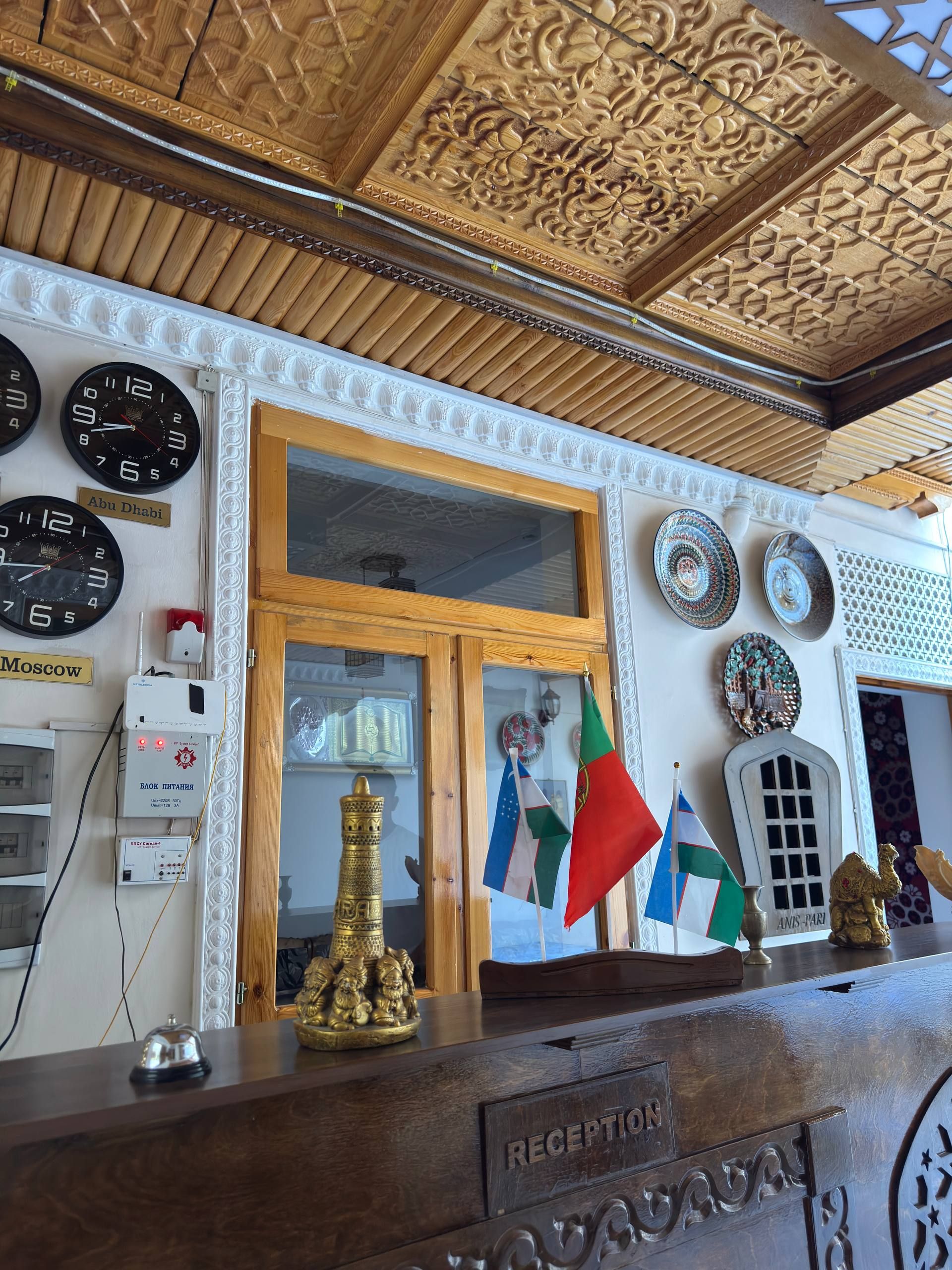 A reception desk with a wooden finish, a clock, and a glass door.