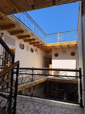 A building with a balcony, a staircase, and a view of the sky. - ANIS-PARI Hotel (Bukhara)