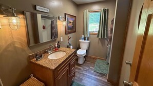 Une salle de bain avec un meuble-lavabo à deux vasques, des toilettes et un espace douche.