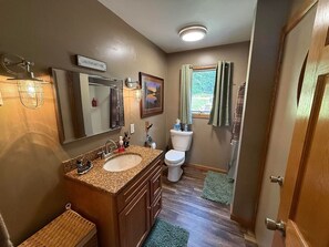Ein Badezimmer mit doppeltem Waschbecken, Toilette und Duschbereich.