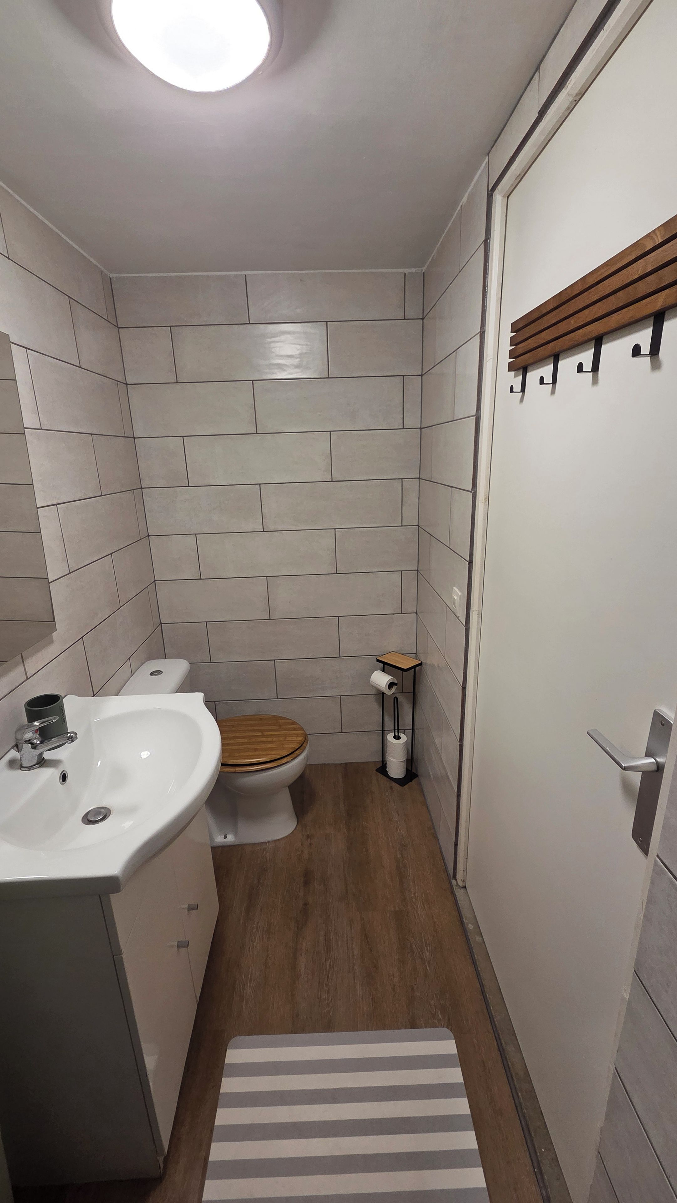 Ein Badezimmer mit Toilette, Waschbecken und Holzboden.
