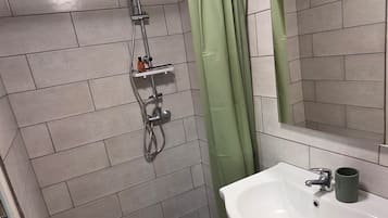 Une salle de bain moderne avec une douche, un lavabo et un miroir.