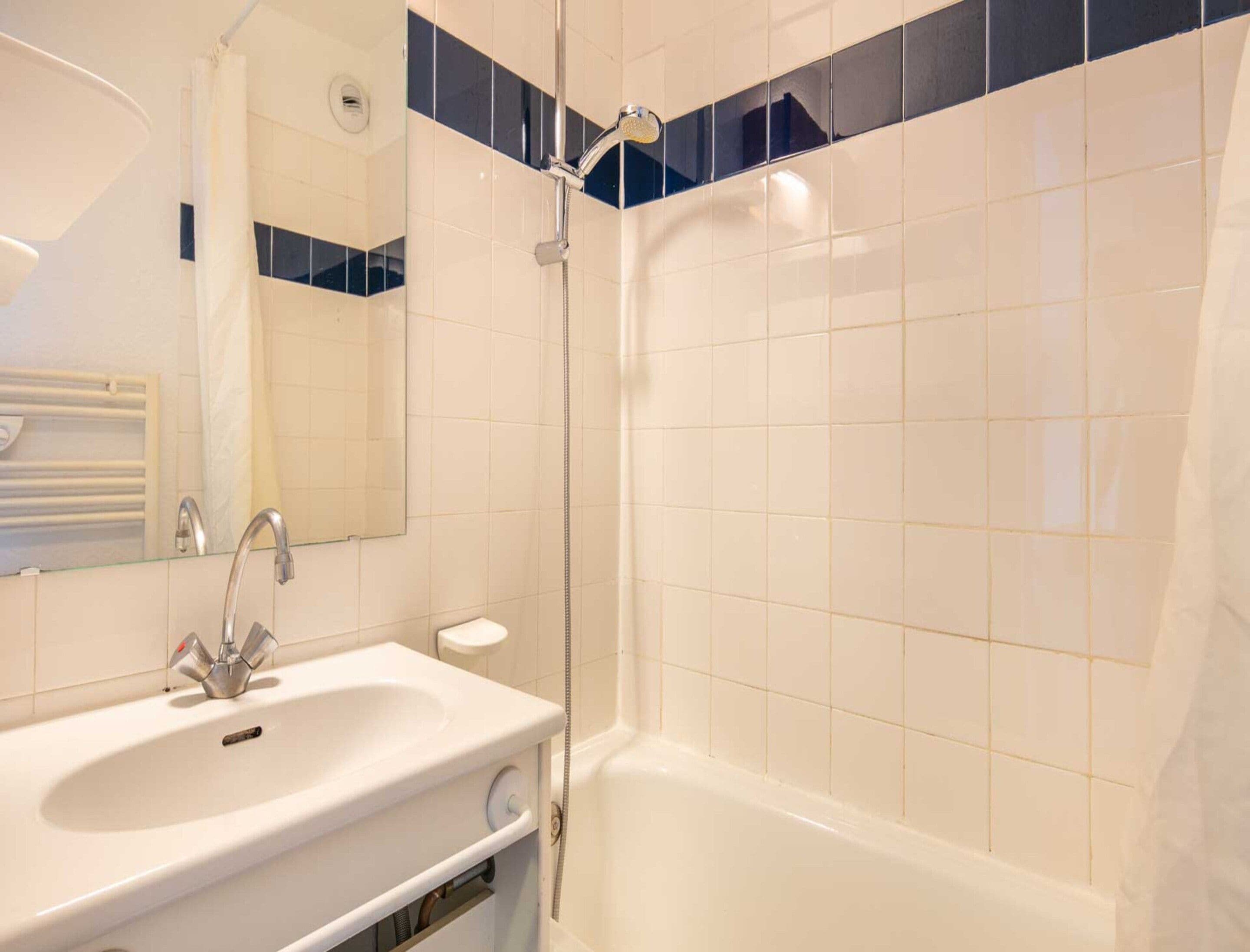 Un bagno con un lavandino bianco, uno specchio, una doccia e una vasca da bagno.