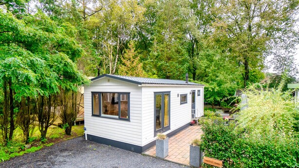 A small, single-story house with a gravel driveway and a garden area. - Vrbo Property (Putten)
