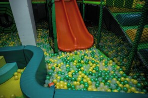 A play area with a slide and a ball pit filled with yellow and green balls. - 2-bedroom Afro-chic apartment at Riara One Residency, Lavington, Nairobi (Nairobi)