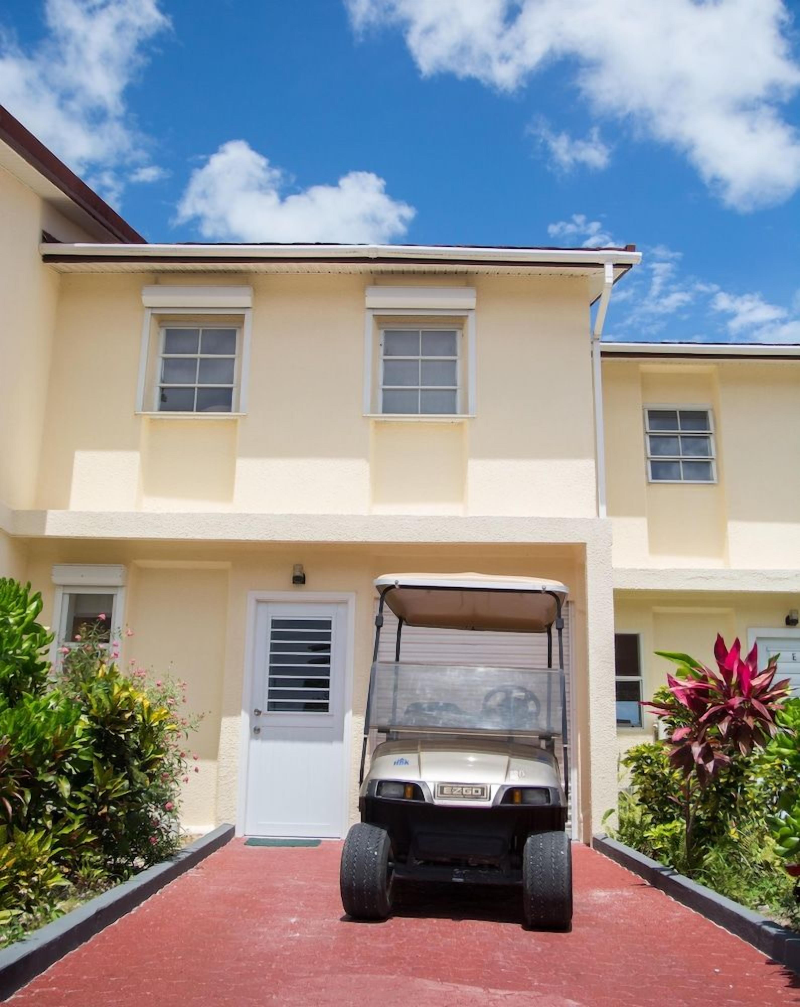 A two-story building with a parked vehicle in front.