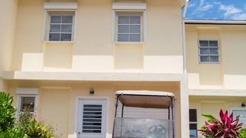 A two-story building with a parked vehicle in front.