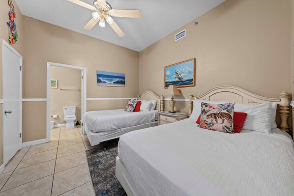 A hotel room with two beds, a ceiling fan, a painting of a ship, and a view of the ocean. - 🌊 Beachfront Gulf Views | Indoor & Outdoor Pools | Phoenix V 116 (Orange Beach)