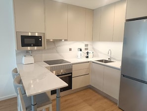 A modern kitchen with a built-in microwave, toaster, and stainless steel refrigerator. - Executive Suite with Swimming Pool & Gym (Gibraltar)