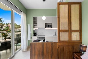A modern kitchen with a built-in microwave, a coffee maker, and a sink. - Jacana | Luxury Resort + Infinity Pool (Bucerías)