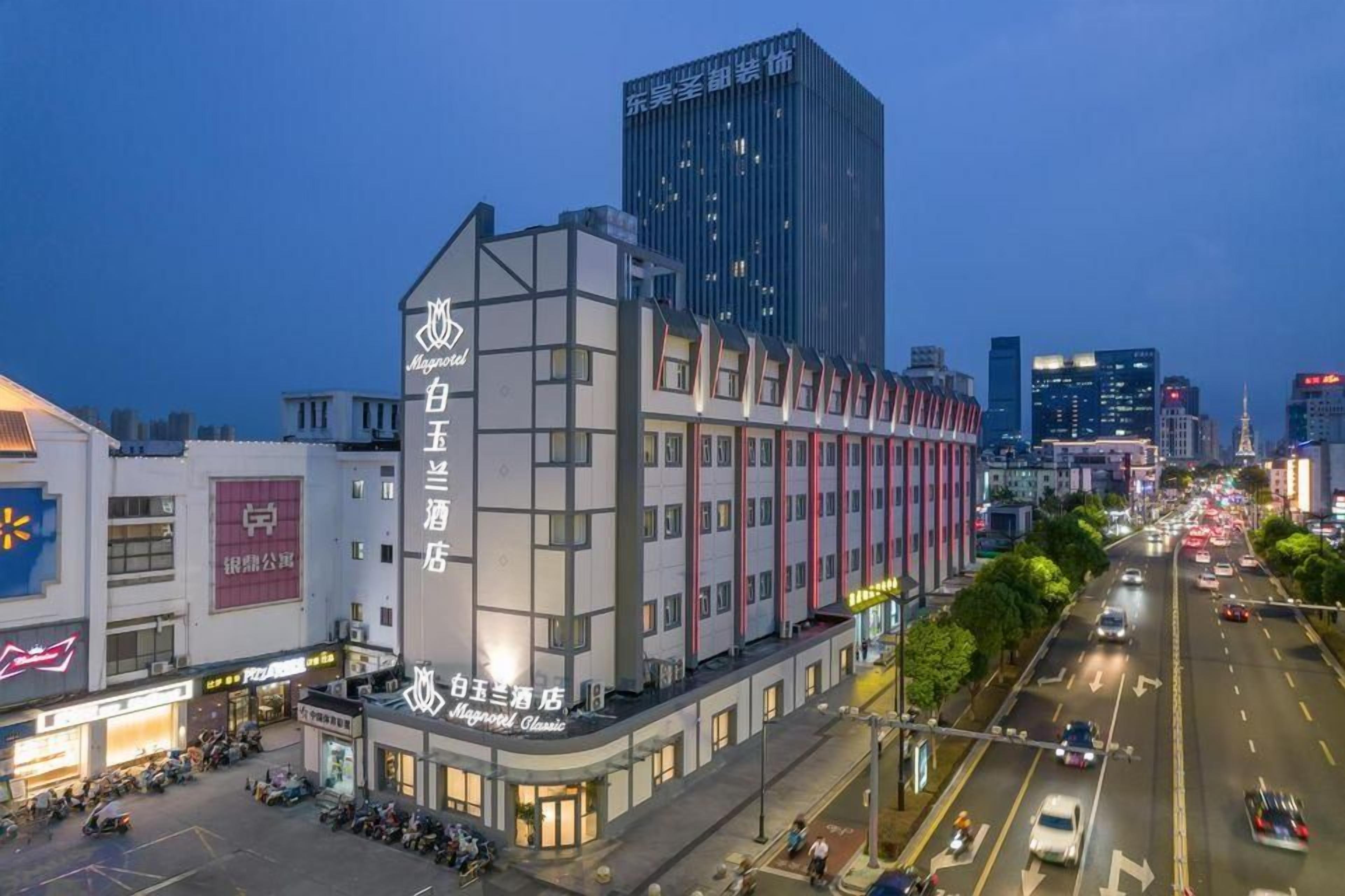 Un hotel con fachada moderna, varios pisos y señalización llamativa.