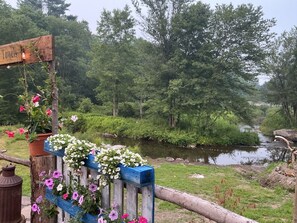 A wooden fence with a sign reading 'Towels' and a river in the background.