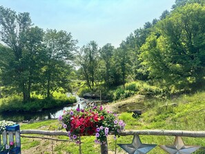 A riverside view with a wooden fence, a wheelbarrow, and a star-shaped decoration. - La Casa del Río 4BR Retreat with Private River Access & Fire Pit (Dallas)