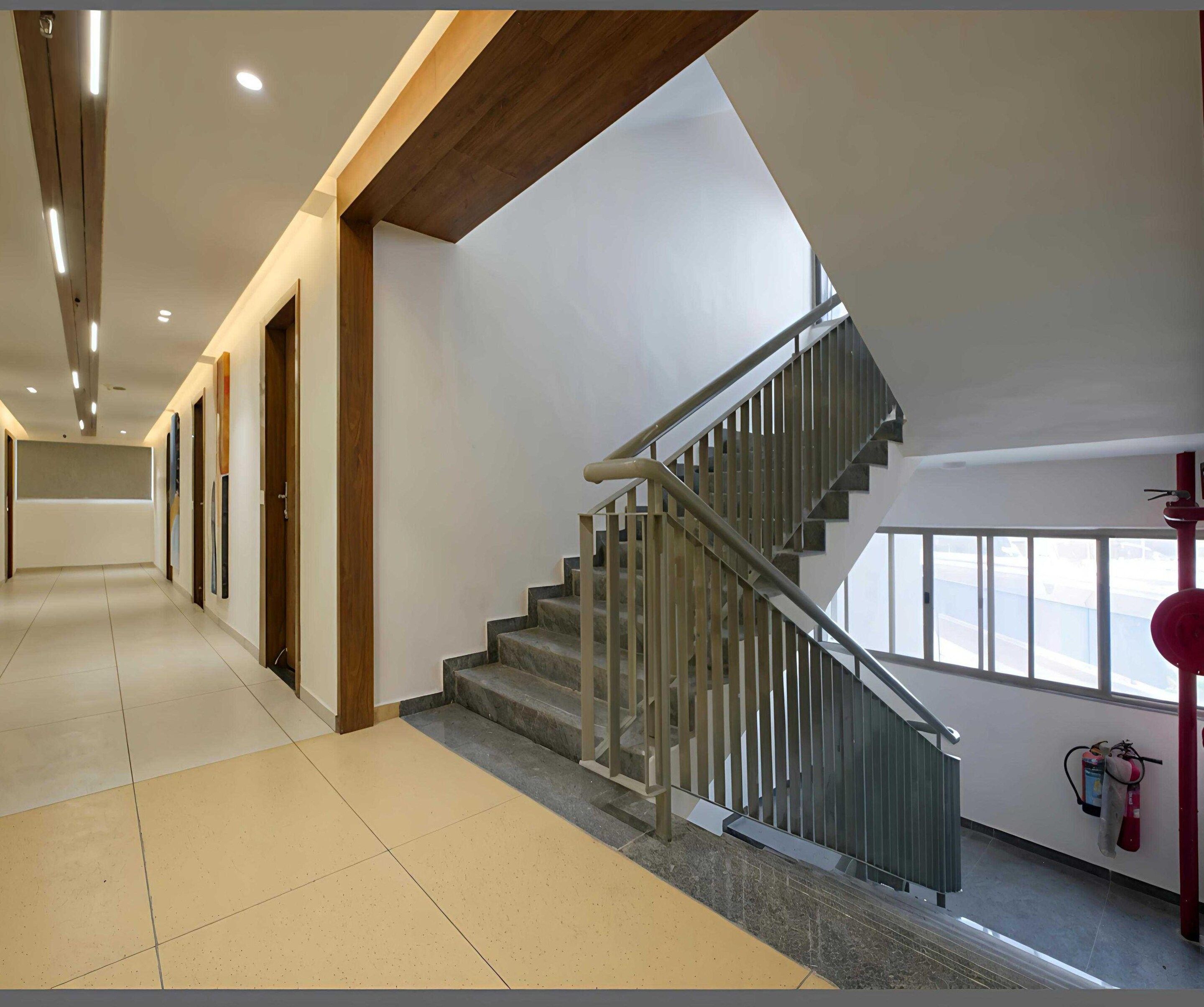 A modern interior with a staircase, a hallway, and a fire extinguisher.