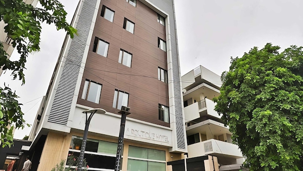 Un hôtel moderne, avec un bâtiment à toit plat, de nombreuses fenêtres et une enseigne indiquant qu’il s’agit d’un hôtel de charme.