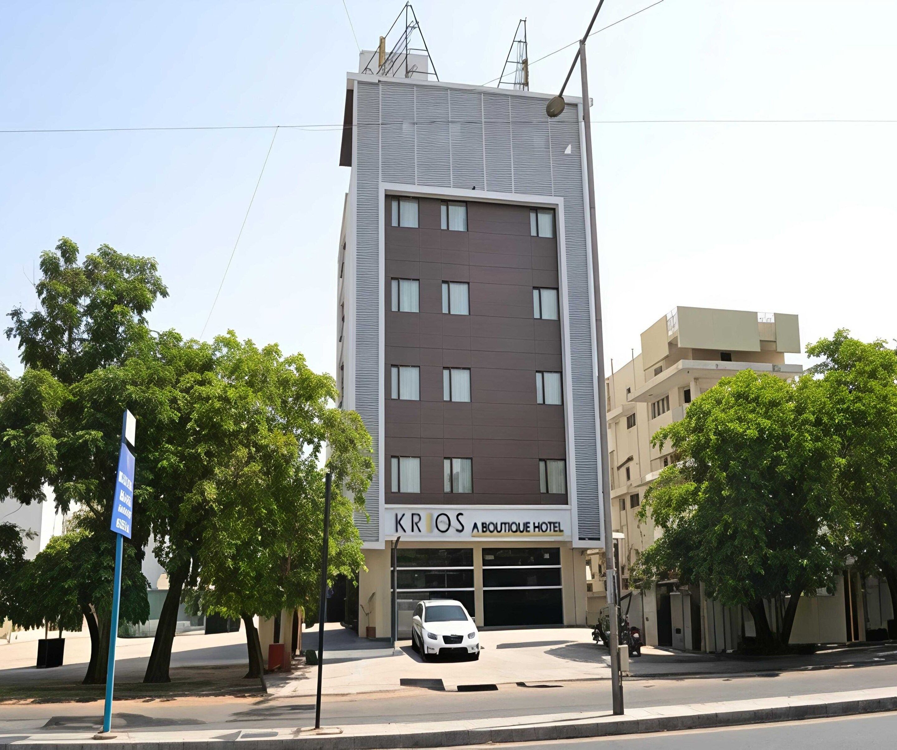 A modern hotel building with a sign for 'KRIOS A BOUTIQUE HOTEL' on the facade.