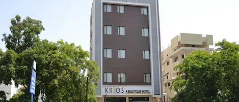 Un moderno edificio de hotel con un letrero que dice 'KRIOS A BOUTIQUE HOTEL' en la fachada.